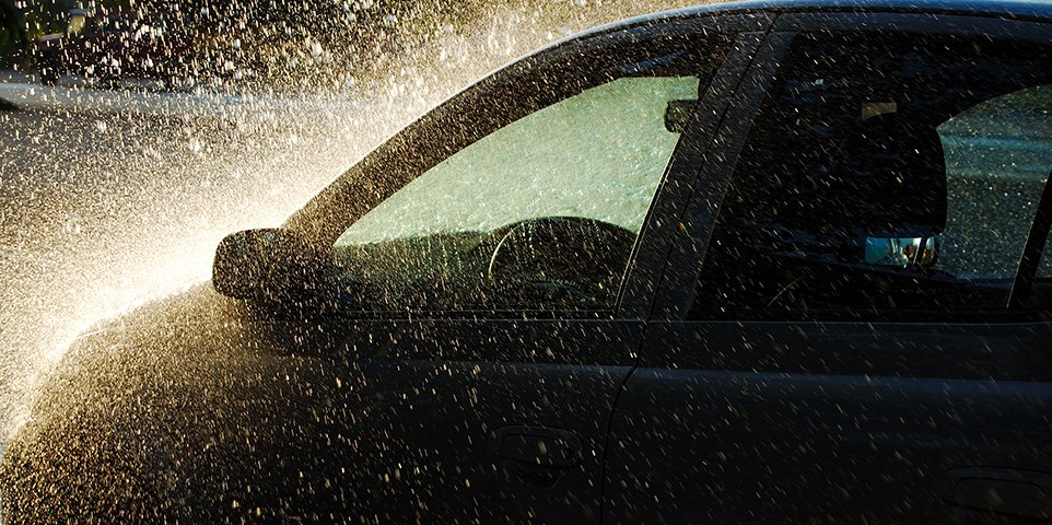 Hail and rain bouncing off a dark car window during a storm